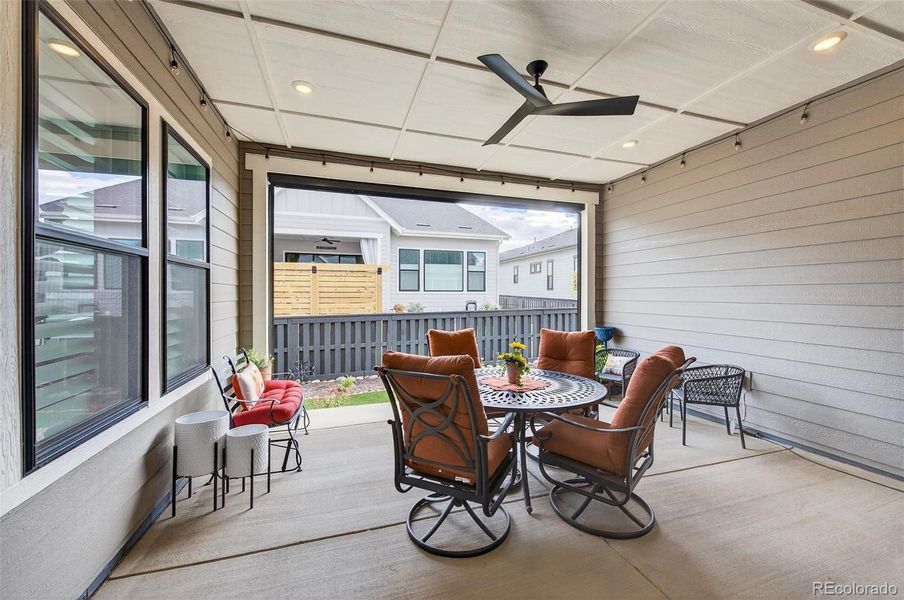 Covered Patio (View 1) – Inviting covered patio with ceiling fan, recessed lighting, and ample seating space, offering a perfect spot for outdoor dining or relaxing year-round.