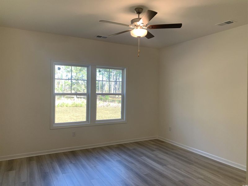 Empty room with wood finished floors and ceiling fan