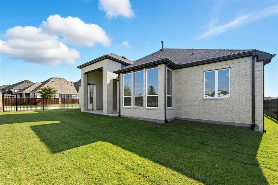 Rear view of property with a patio, a fenced backyard, brick siding, and roof with shingles Rear view of property with a patio, a fenced backyard, brick siding, and roof with shingles
