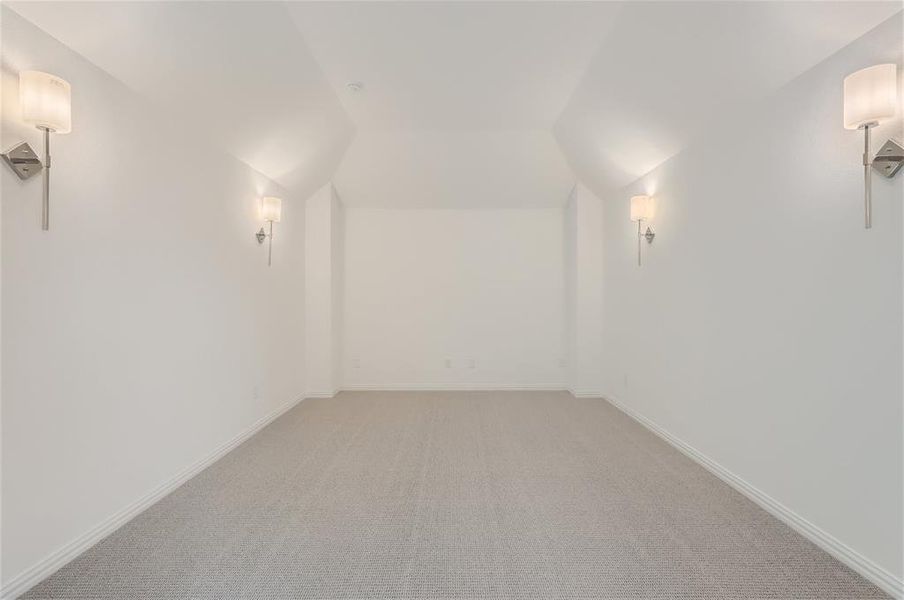 Bonus room featuring vaulted ceiling and carpet floors