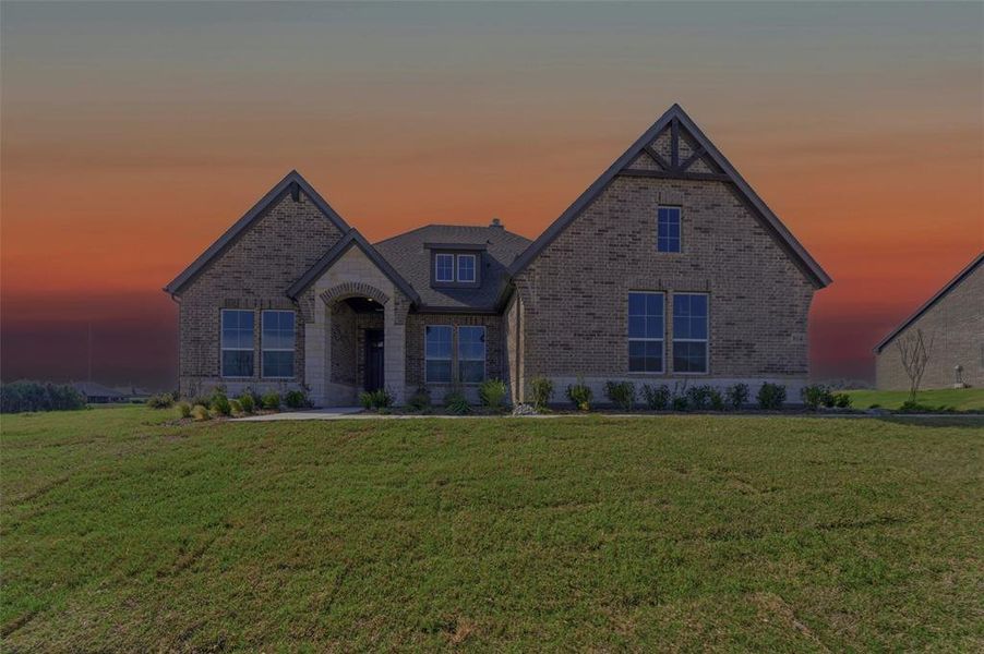 View of front facade featuring brick siding and a front lawn