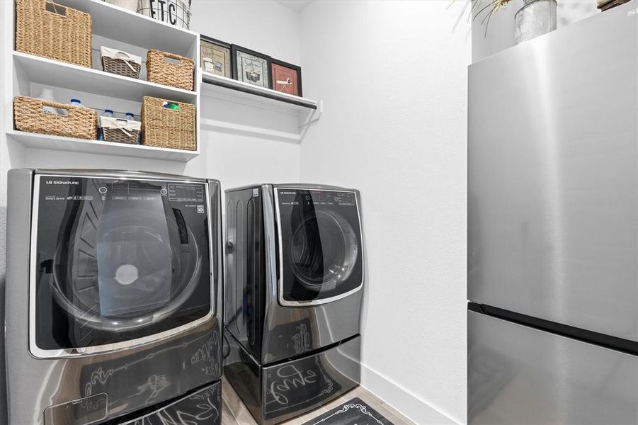 Separate laundry room with shelfing and room for second refrigerator or freezer.