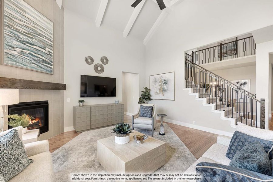 Living room with vaulted beamed ceiling, tile fireplace, hardwood floors, and open staircase with metal railing
