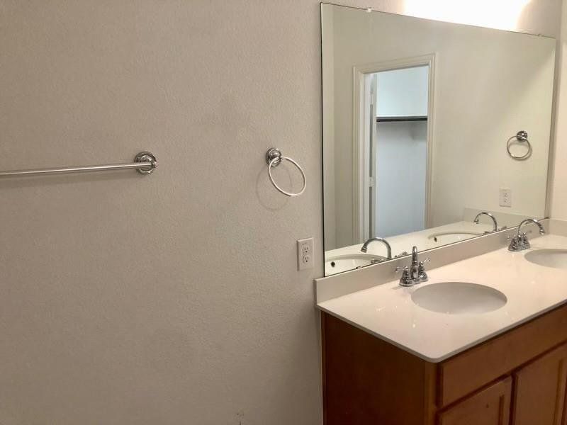 Bathroom featuring a textured wall and double vanity Bathroom featuring a textured wall and double vanity