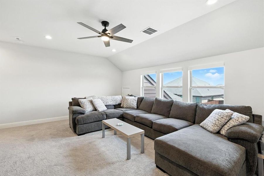 Living room featuring recessed lighting, light colored carpet, vaulted ceiling, and a ceiling fan