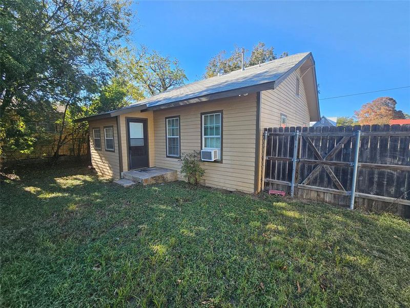 Rear view of property featuring a lawn and cooling unit Rear view of property featuring a lawn and cooling unit