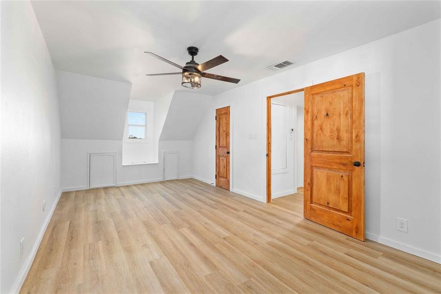 Bonus room featuring light wood-type flooring, lofted ceiling, and ceiling fan