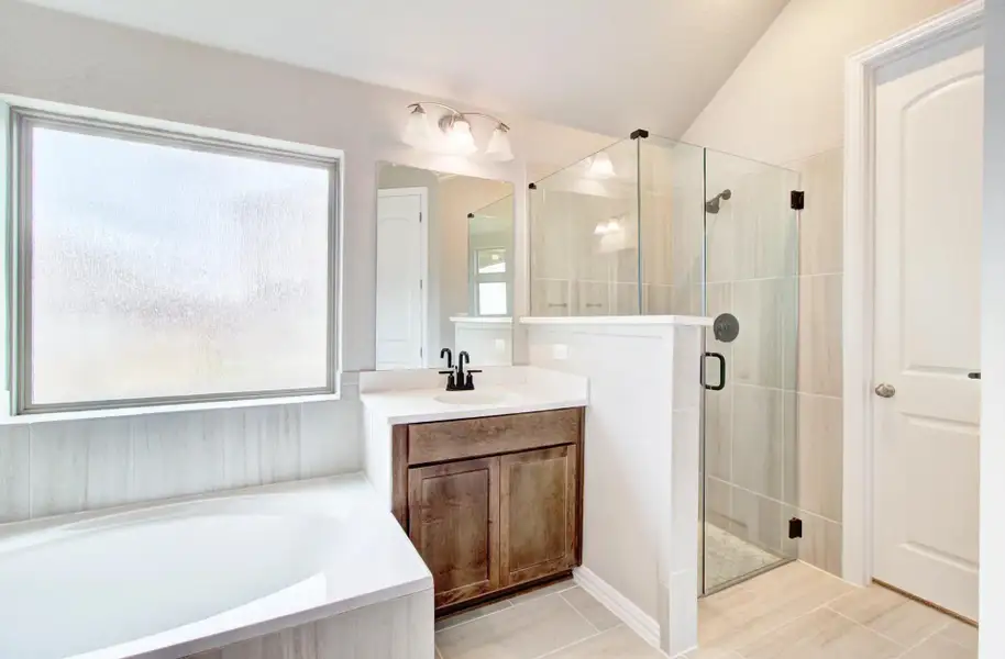 Full bath with vanity, a bath, a shower stall, and lofted ceiling Full bath with vanity, a bath, a shower stall, and lofted ceiling