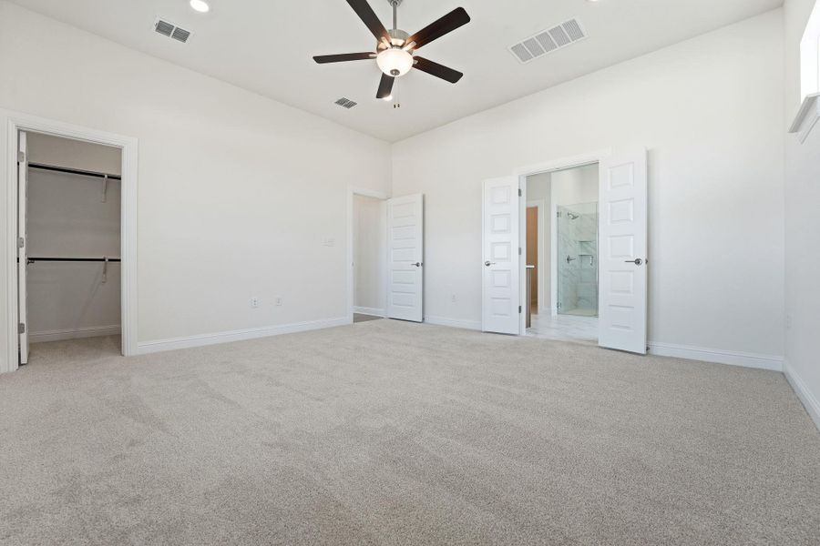 Unfurnished bedroom featuring light colored carpet, ceiling fan, recessed lighting, and connected bathroom