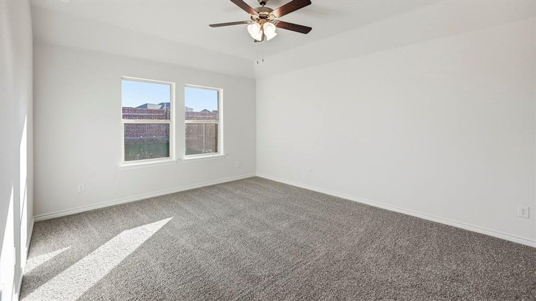 Carpeted empty room featuring baseboards and ceiling fan Carpeted empty room featuring baseboards and ceiling fan