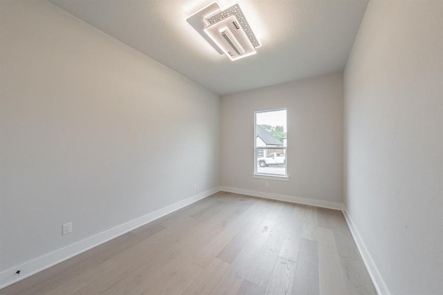 Spare room featuring baseboards and light wood-style floors