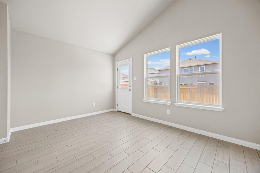 An angled ceiling and wood-look tile flooring define this light-filled room. An angled ceiling and wood-look tile flooring define this light-filled room.