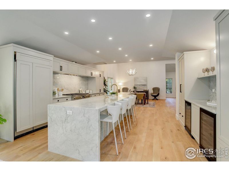 The heart of this home, the chef's kitchen, features an 17ft White Carrara Marble island with waterfall edges and top-of-the-line Monogram appliances. (Refrigerator panels to be replaced next week)