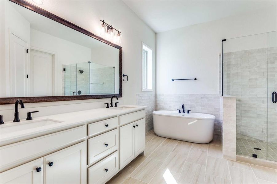 Bathroom with tile walls, vanity, tile patterned floors, and independent shower and bath