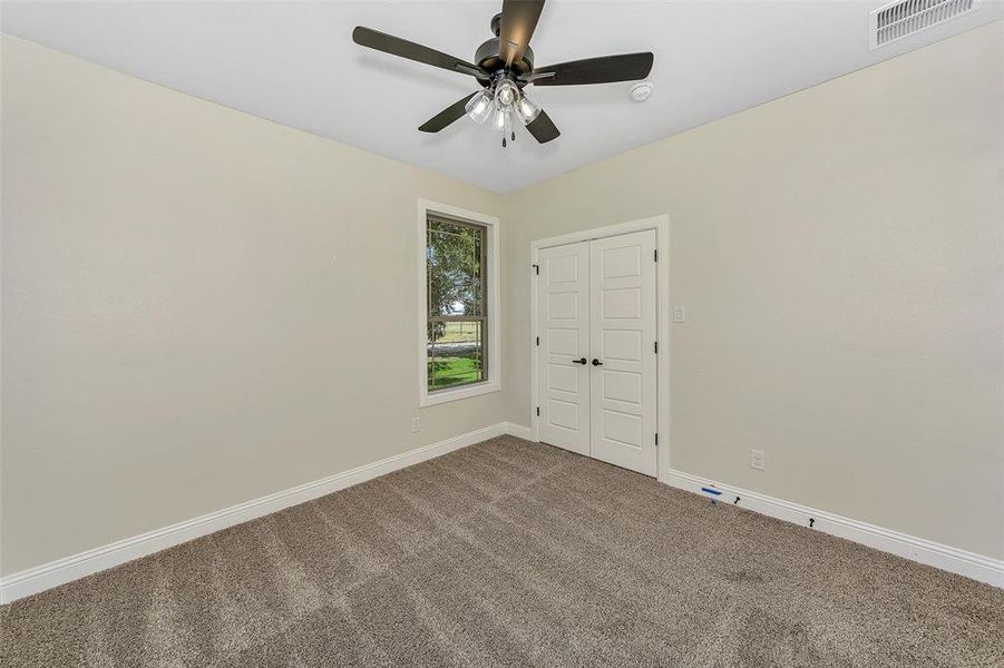 Spare room featuring carpet flooring and ceiling fan