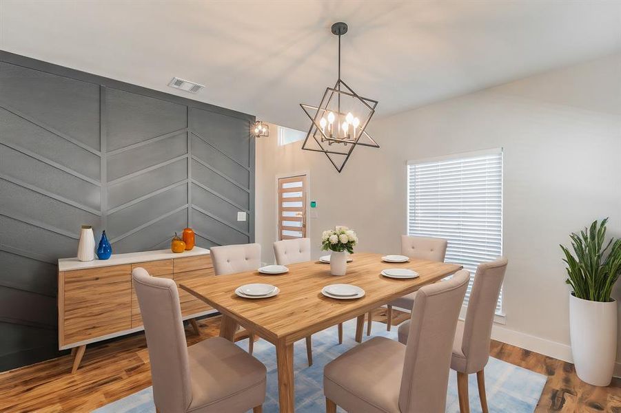 Dining room with a notable chandelier and hardwood / wood-style flooring