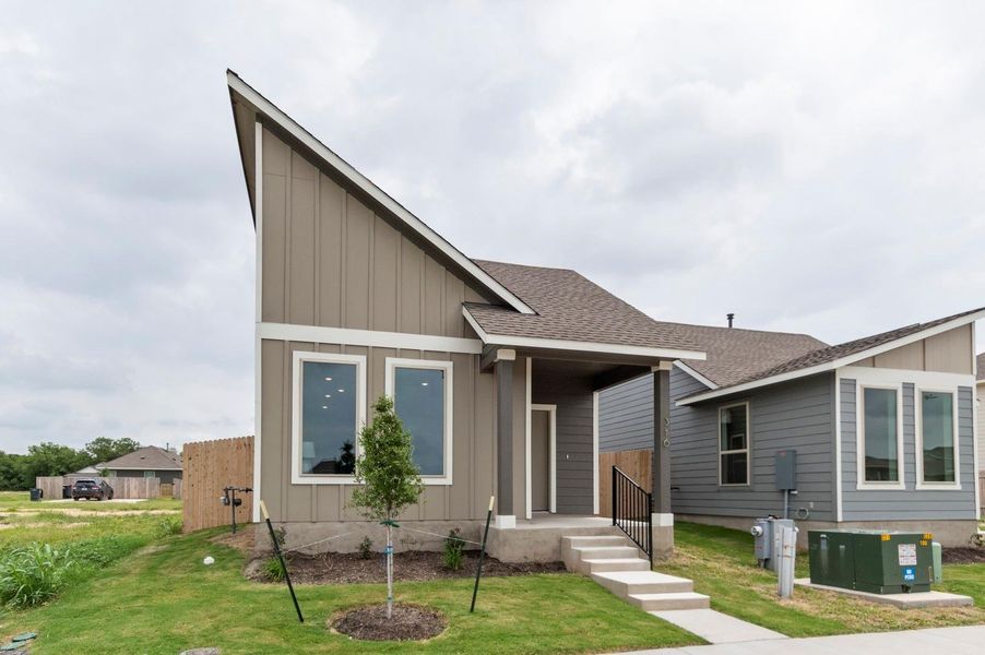 View of front of home with board and batten siding and roof with shingles