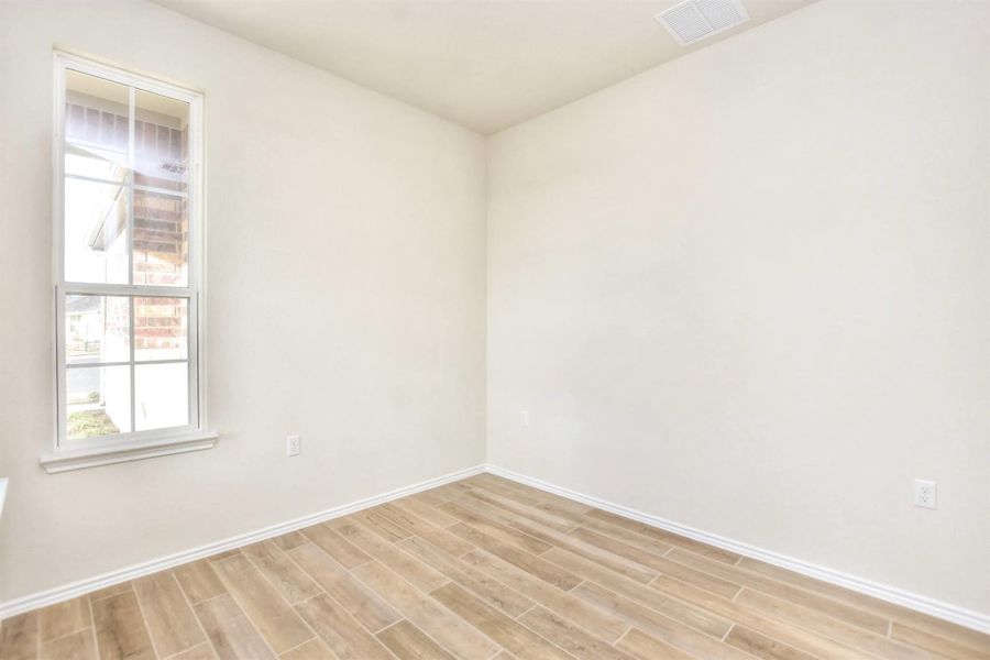 Unfurnished room with visible vents, light wood-type flooring, and baseboards