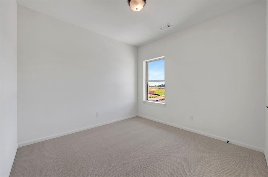 Room featuring light-toned carpeting, white walls, and a single window with white trim Room featuring light-toned carpeting, white walls, and a single window with white trim