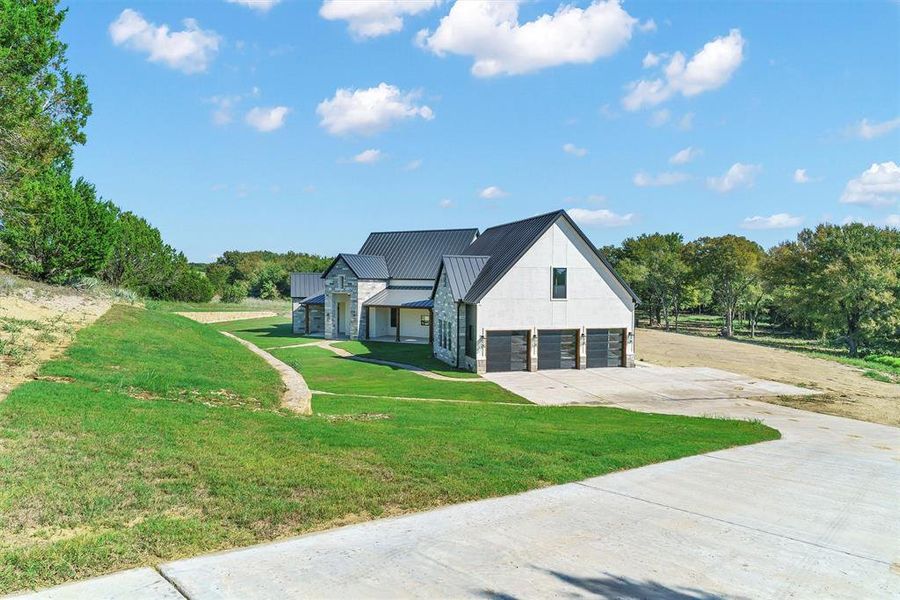 View of front of property featuring a garage and a front lawn