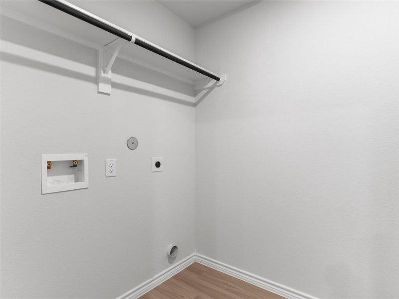 Convenient utility room with washer/dryer hookups and built-in shelving for effortless organization. Convenient utility room with washer/dryer hookups and built-in shelving for effortless organization.