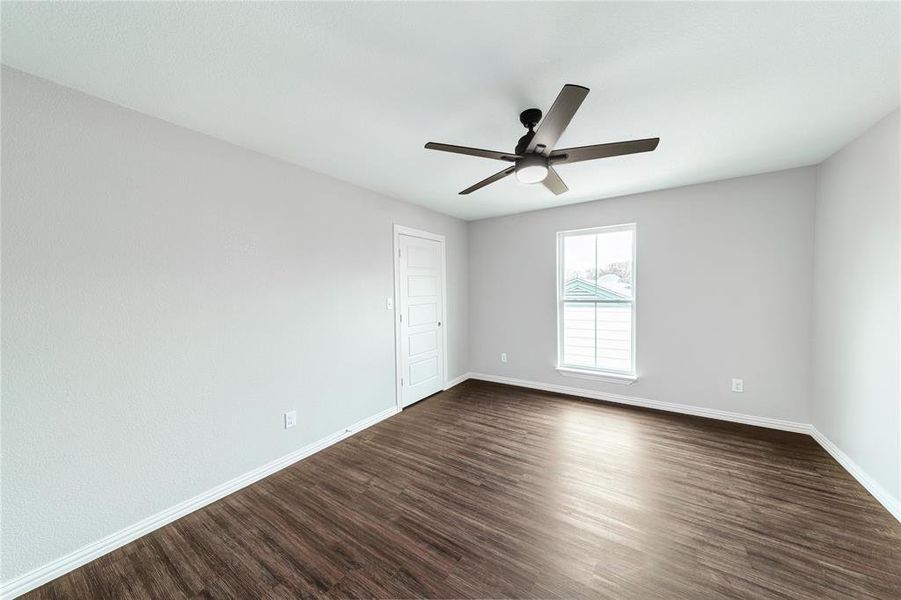 Spare room featuring dark wood-type flooring and a ceiling fan
