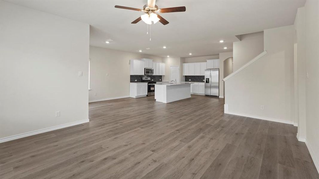 Unfurnished living room featuring recessed lighting, a ceiling fan, and dark wood finished floors Unfurnished living room featuring recessed lighting, a ceiling fan, and dark wood finished floors