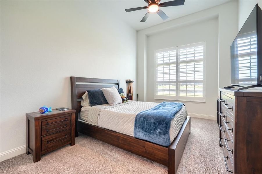 Bedroom featuring a ceiling fan and light colored carpet