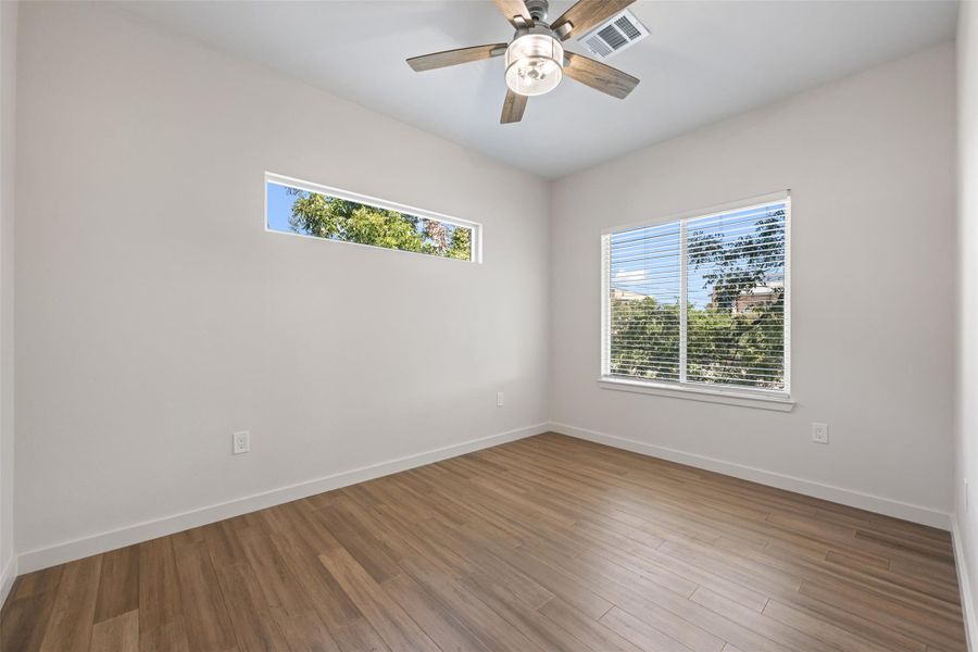 Spare room with wood finished floors and a ceiling fan