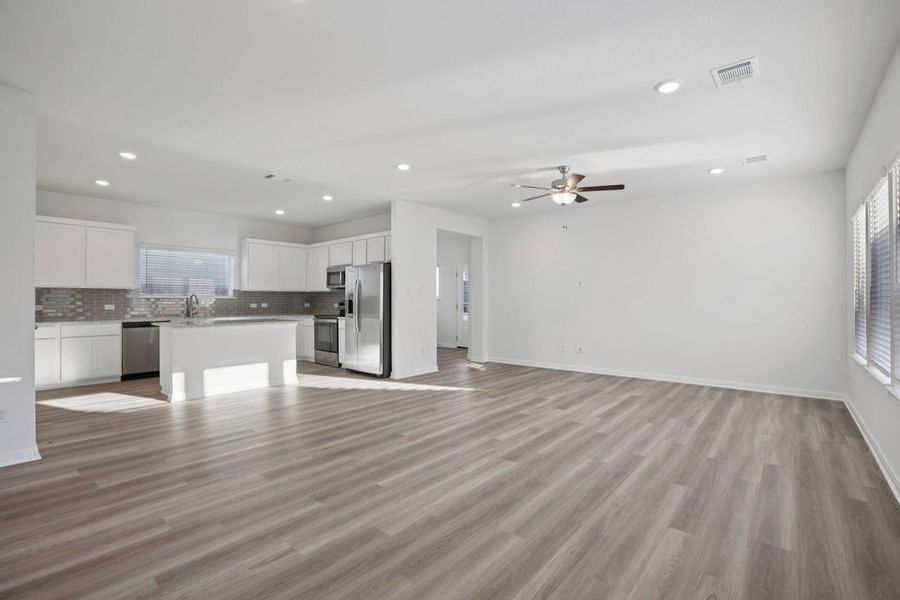 Unfurnished living room featuring a ceiling fan, light wood-type flooring, and recessed lighting