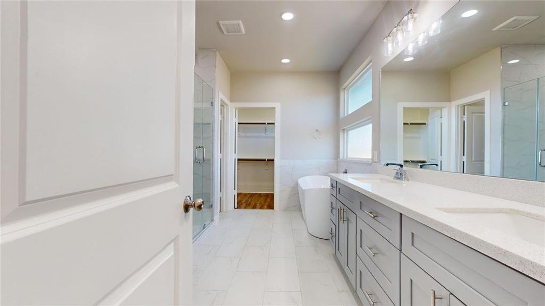 The primary bath features a double vanity, stand-alone soaking tub, free-standing shower and walk-in closet.