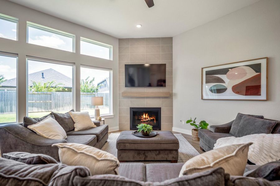This comfortable family room offers plenty of space to settle in, unwind and enjoy the view, with soaring stacked windows and a sleek gas-log fireplace anchoring the space.