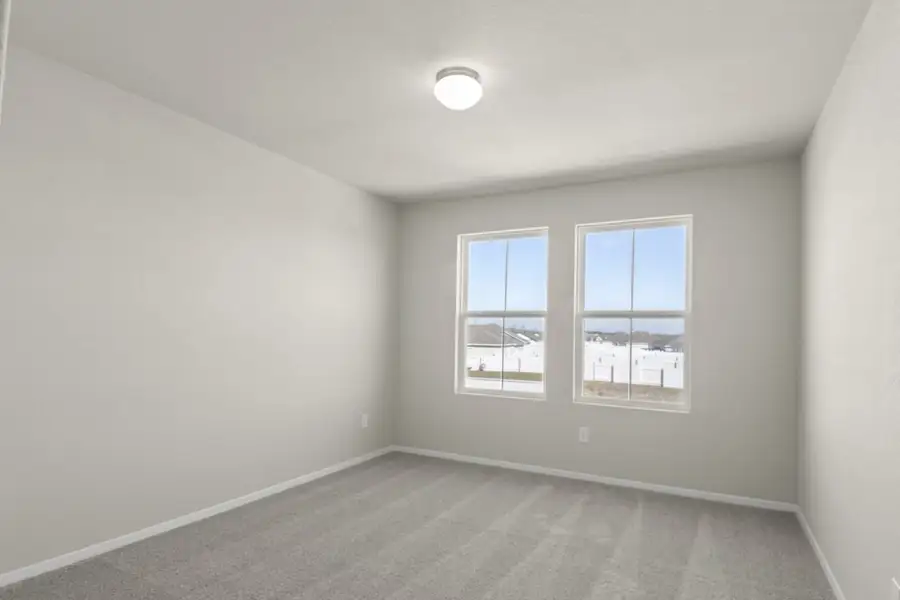 Image of a bedroom with cream walls, tan carpeting, two windows and white trim Image of a bedroom with cream walls, tan carpeting, two windows and white trim
