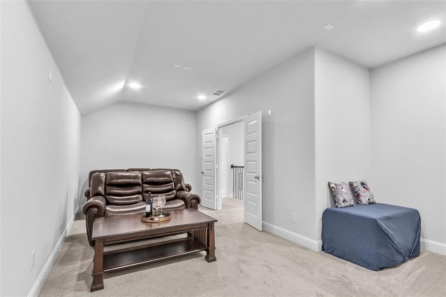 Living area featuring light carpet, recessed lighting, visible vents, and baseboards