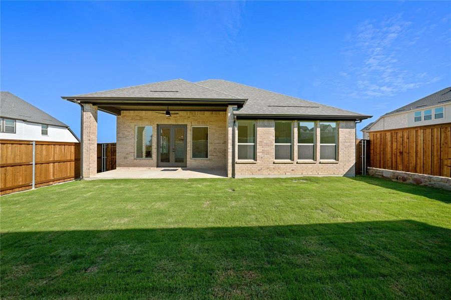 Rear view of property featuring ceiling fan, roof with shingles, brick siding, a patio, and a fenced backyard Rear view of property featuring ceiling fan, roof with shingles, brick siding, a patio, and a fenced backyard