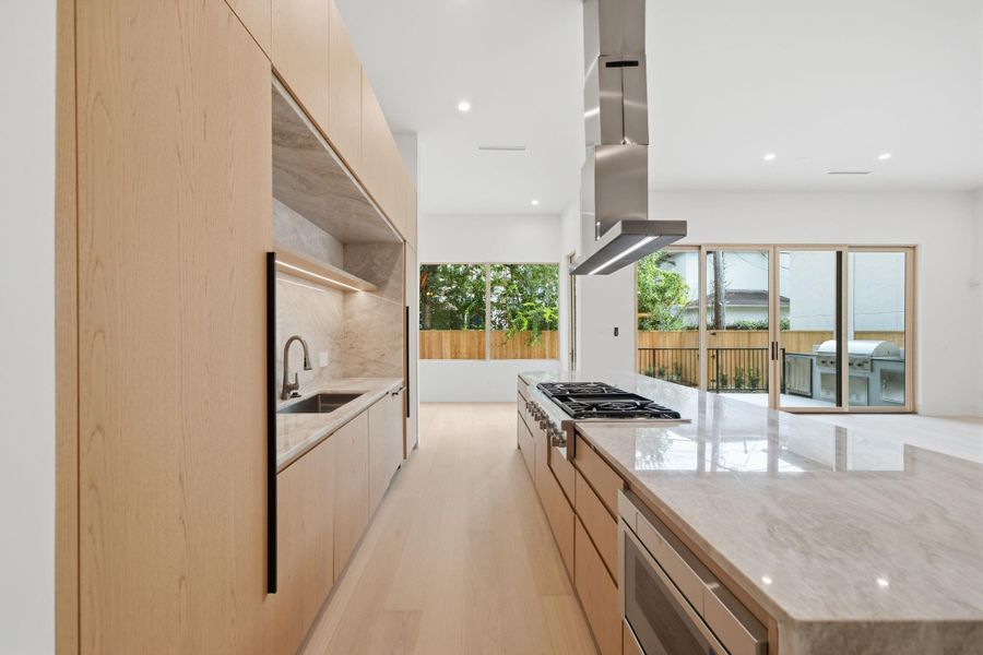 The kitchen and entire home is embraced with exceptional natural light and wood tones