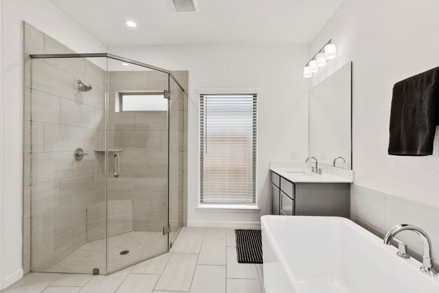 Glass-enclosed shower in the primary ensuite featuring a built-in bench and stylish tile surround. Glass-enclosed shower in the primary ensuite featuring a built-in bench and stylish tile surround.