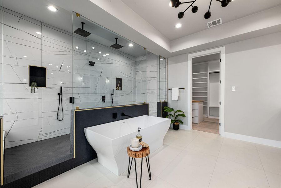 Private primary retreat featuring a spa-inspired bath with double vanities, standalone soaking tub, walk-in shower, and walk-in closet. Private primary retreat featuring a spa-inspired bath with double vanities, standalone soaking tub, walk-in shower, and walk-in closet.