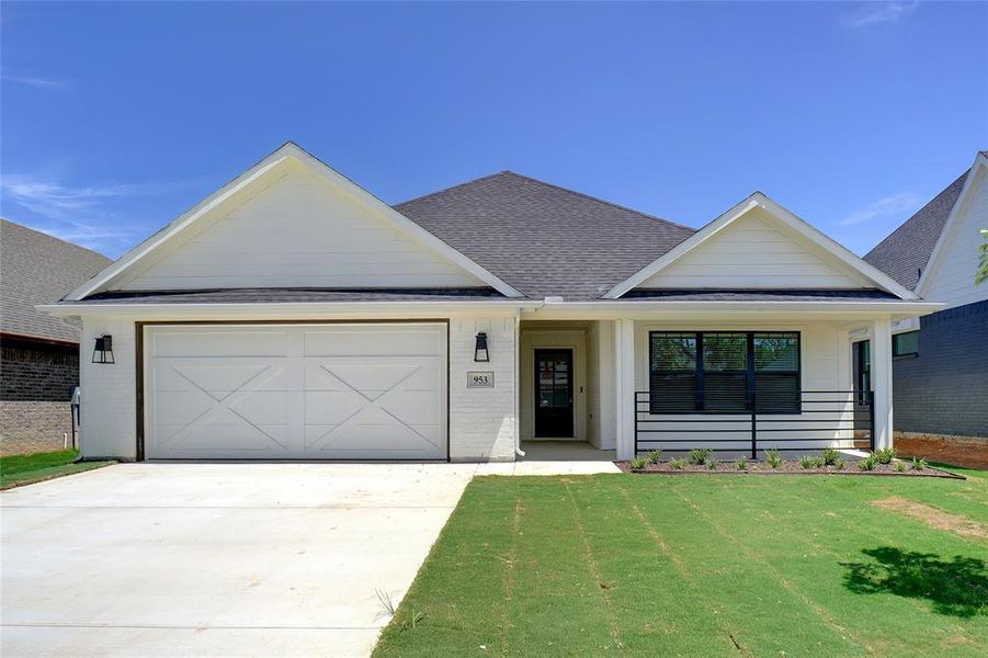 View of front of property featuring a garage and a front yard