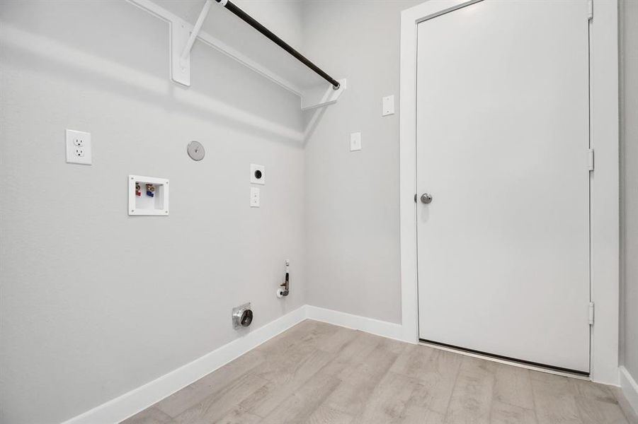 A spacious utility room with ample shelving for organization. It features connections for both gas and electric dryers, making it versatile and functional for all laundry needs.  Sample photo of completed home with similar plan. As built color and selections may vary.