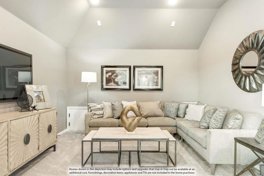 Living room with vaulted ceiling, gray sectional sofa, coffee table, and large TV on a sideboard