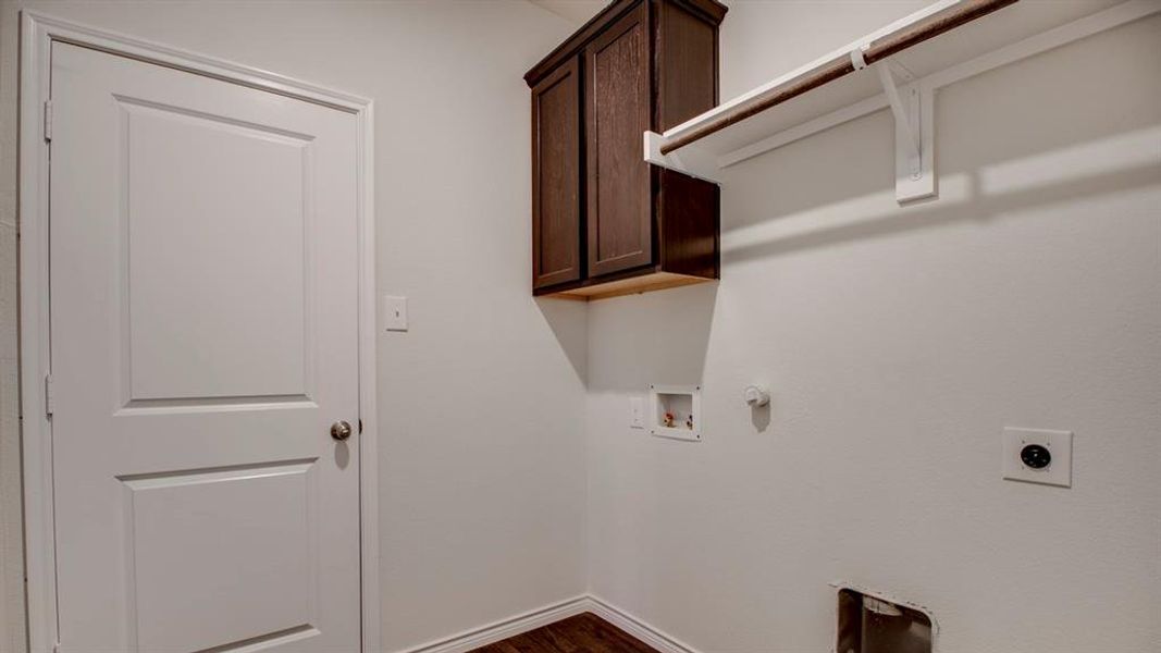 Laundry area featuring gas dryer hookup, dark wood-style flooring, hookup for a washing machine, cabinet space, and hookup for an electric dryer Laundry area featuring gas dryer hookup, dark wood-style flooring, hookup for a washing machine, cabinet space, and hookup for an electric dryer