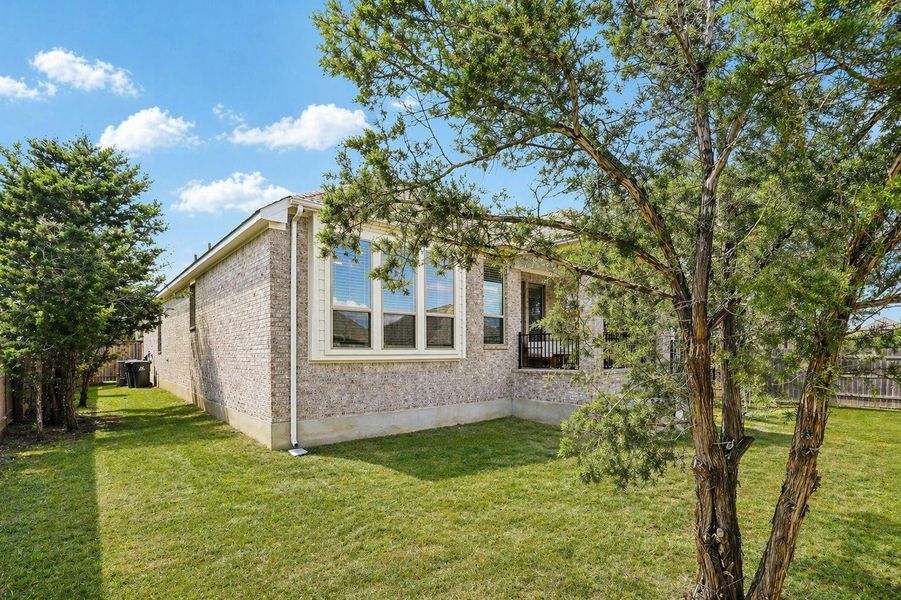 A neatly maintained lawn provides a verdant backdrop to the brick-clad dwelling.