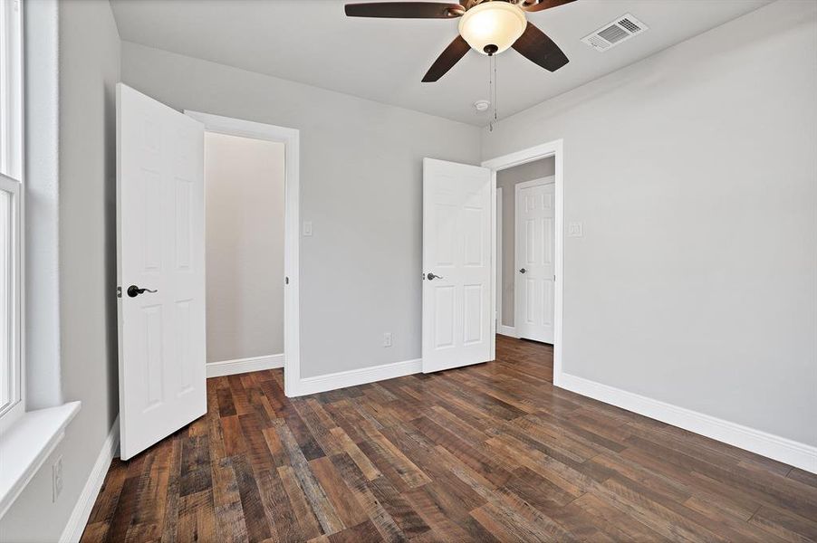 Unfurnished bedroom with dark hardwood / wood-style floors and ceiling fan