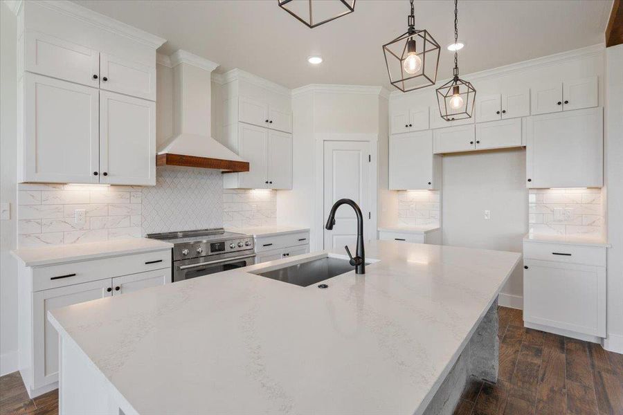 A pristine culinary space boasts an expansive island with a sink and modern fixtures, ready for gourmet creations.