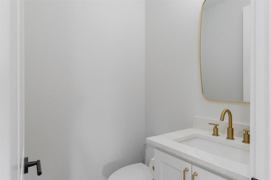 Half bathroom featuring vanity and toilet