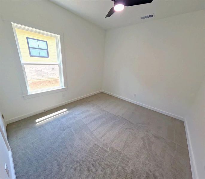 Carpeted empty room featuring baseboards and ceiling fan Carpeted empty room featuring baseboards and ceiling fan