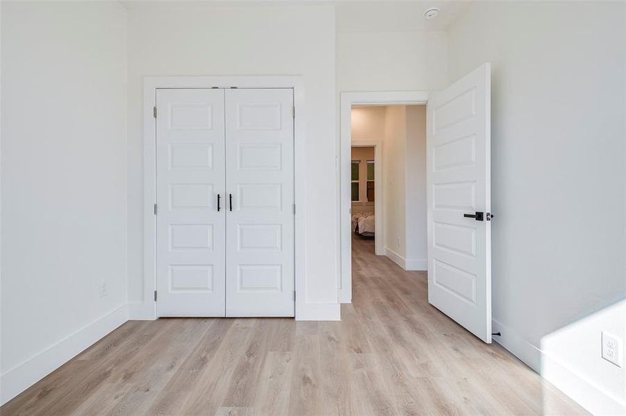 Unfurnished bedroom with light hardwood / wood-style flooring and a closet