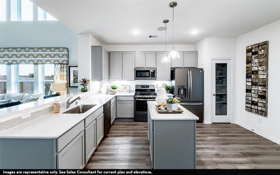 Kitchen featuring light gray cabinetry, stainless steel appliances, a center island with countertop, and wood-finish flooring Kitchen featuring light gray cabinetry, stainless steel appliances, a center island with countertop, and wood-finish flooring