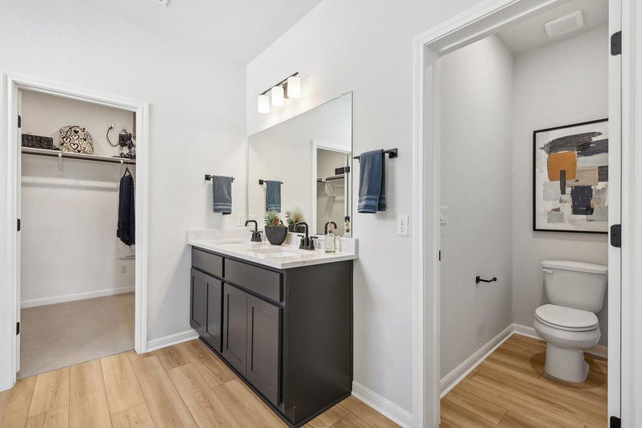 Dual vanities and a private water closet create a serene and organized primary bathroom retreat. Dual vanities and a private water closet create a serene and organized primary bathroom retreat.
